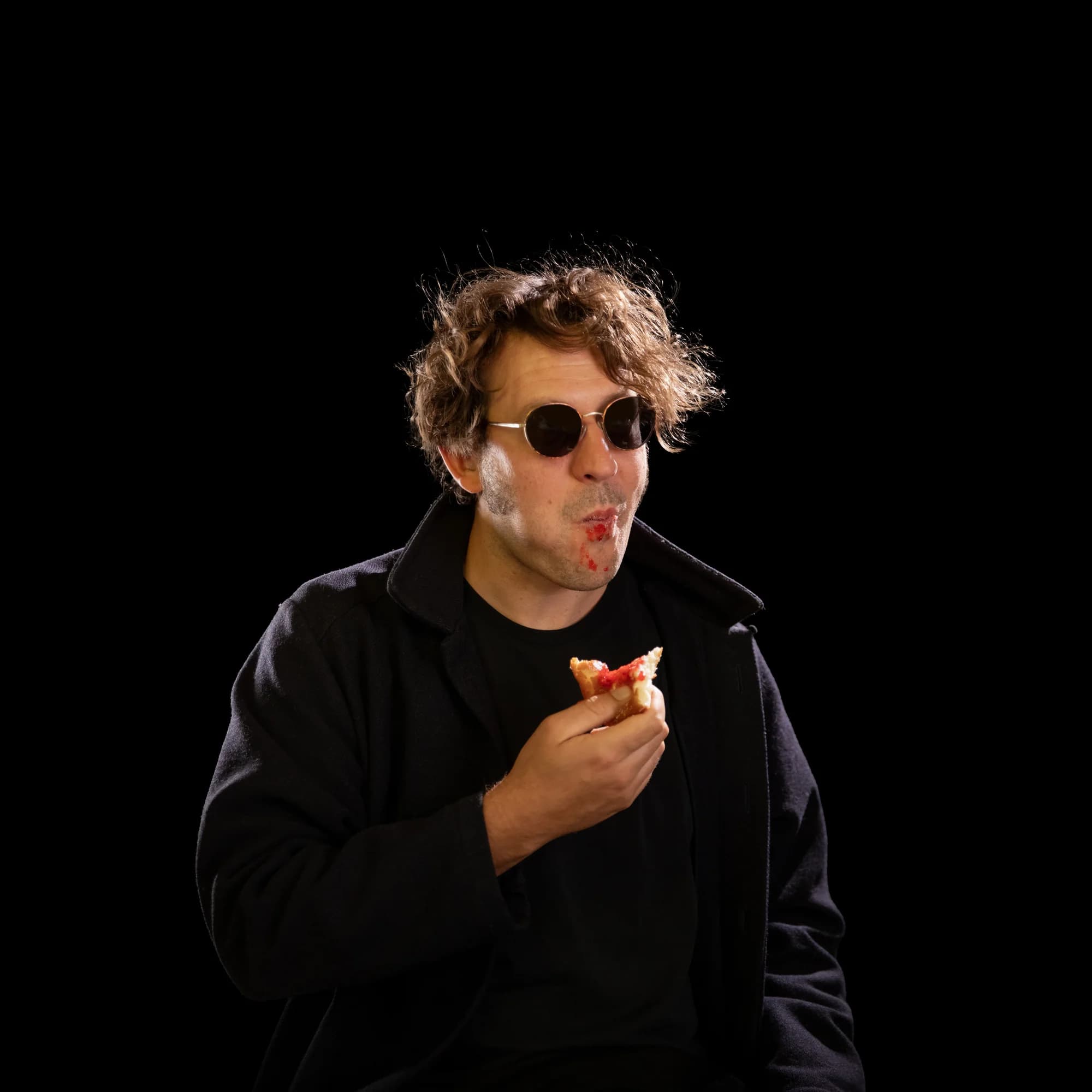 Harvey Pink wearing sunglasses against black