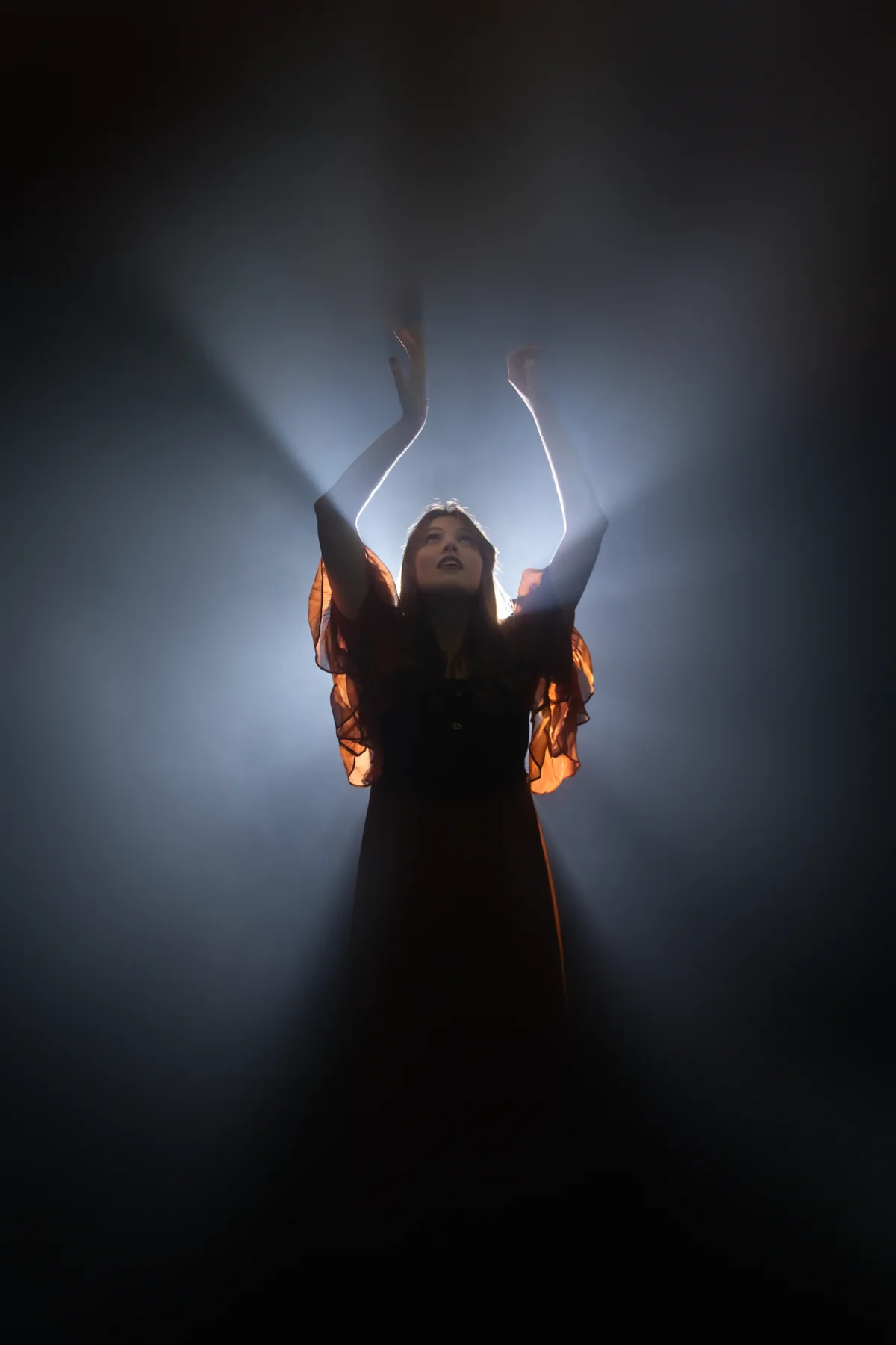 Sadie Mustoe reaching into a smoky backlight