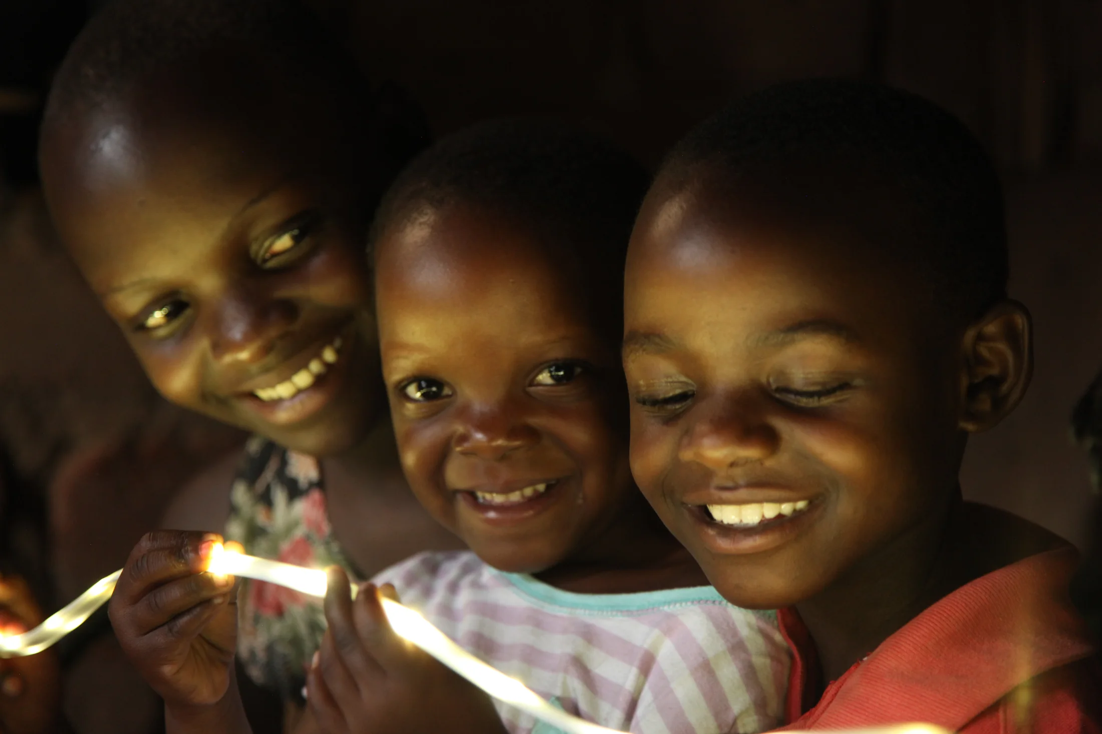 Children gathered around a shaft of afternoon light