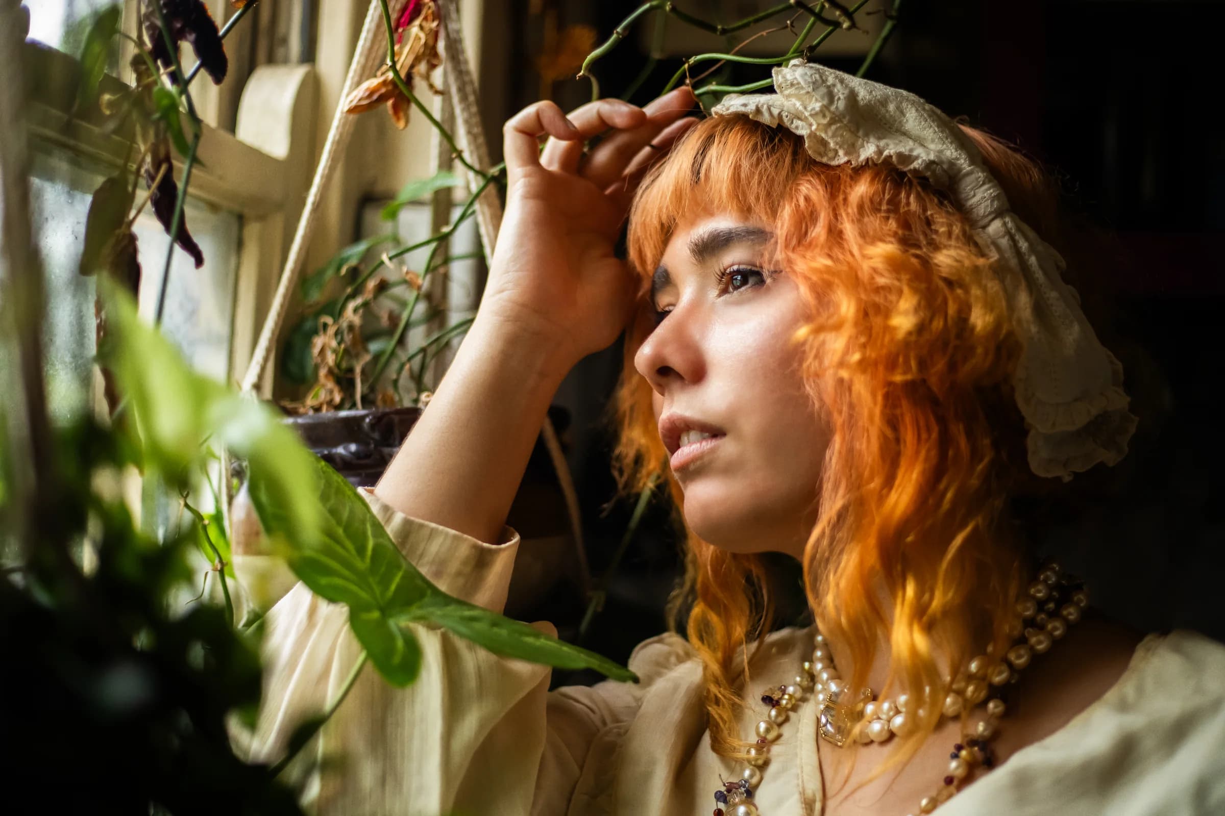 Inge Berman framed by plants in a colourful kitchen