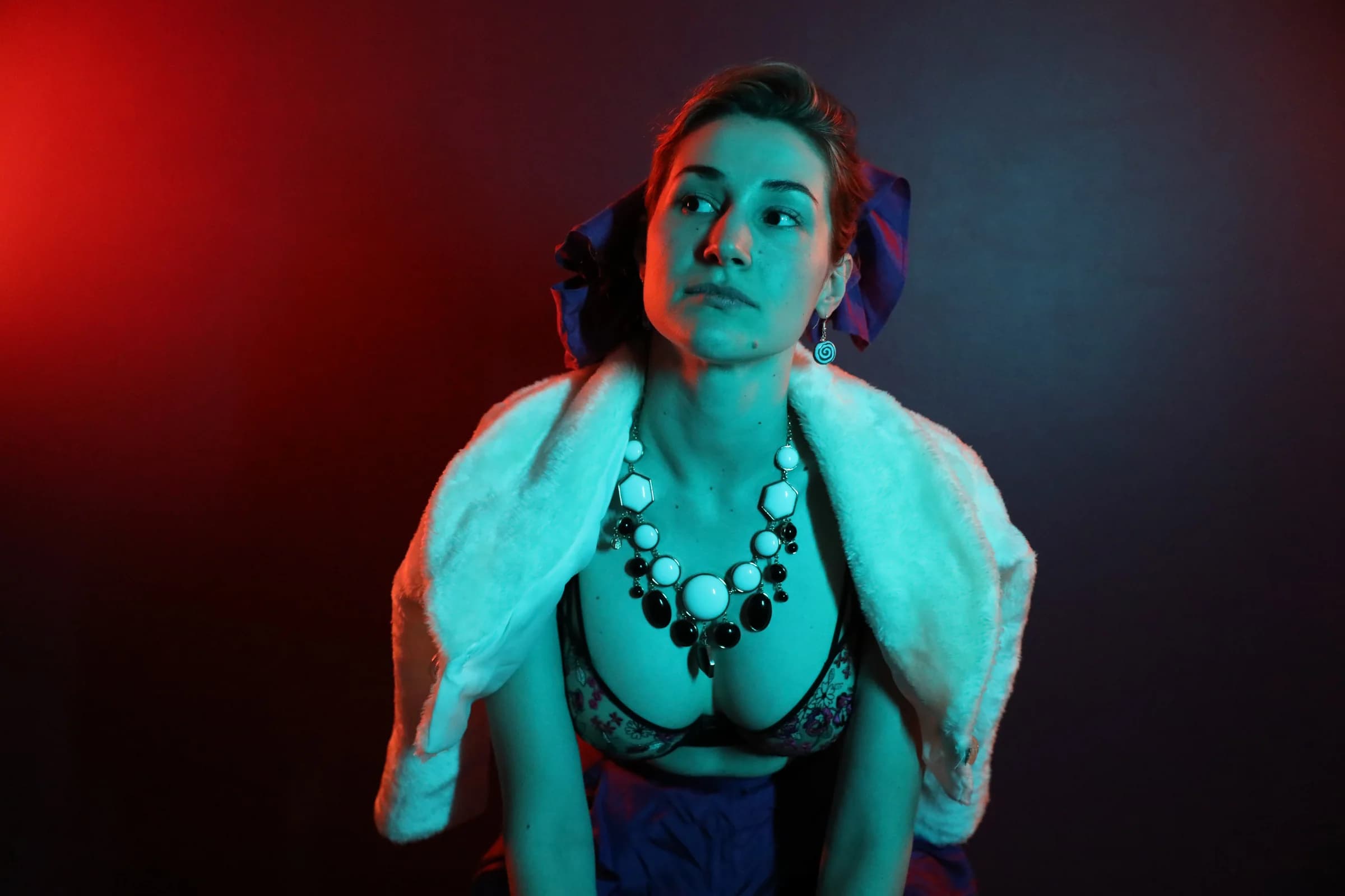 Christiane in vivid red and cyan light wearing op-shop fashion
