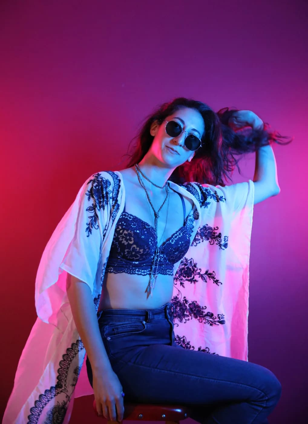 Ella wearing sunglasses under vivid blue light